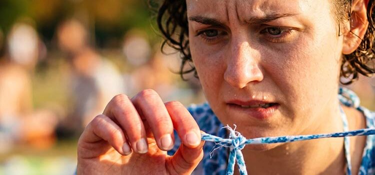 Frau schaut ängstlich auf den Verschluß ihres Kleides - Angst bestimmt ihren Alltag (Foto: © MT, Adobe Stock)